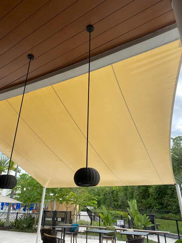Under the canvas of an outdoor bar seating area.